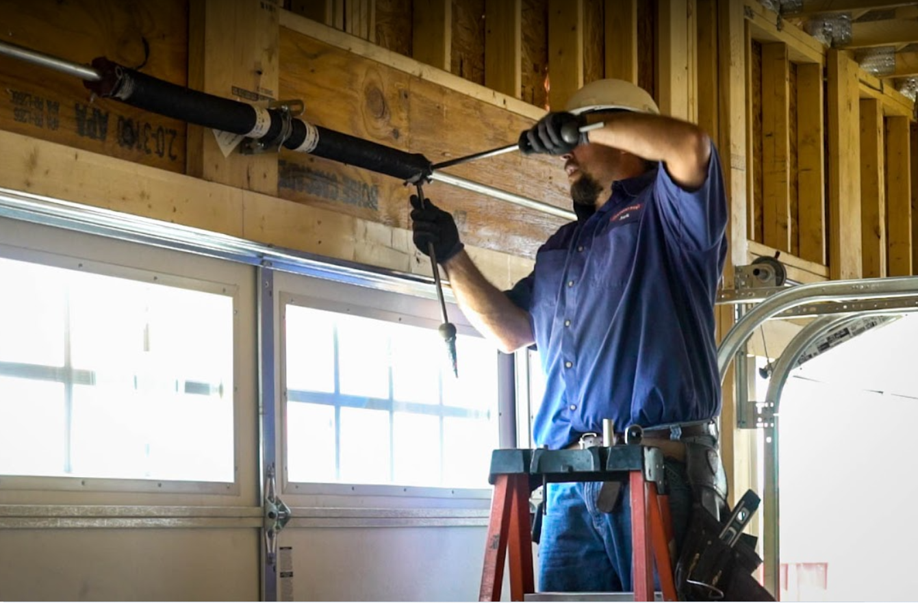 Garage door technician repairing torsion spring in San Diego